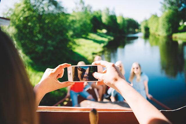 Ystävykset ottavat selfien jokirannassa