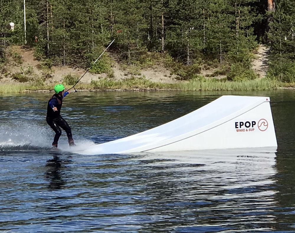 Wakeboarding lautailija lähestyy hyppyriä vedessä