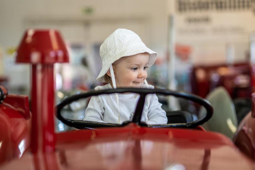 Lapsi traktorin ratin takana traktorin kyydissä