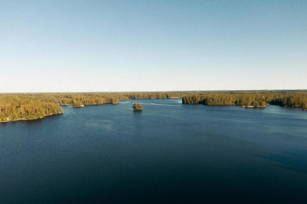 Ilmakuva järvestä ja metsästä horisontissa