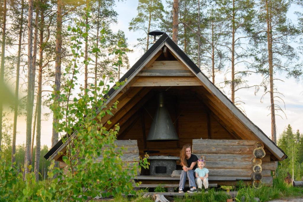 Lapsi ja nainen istumassa avolaavun edessä portailla