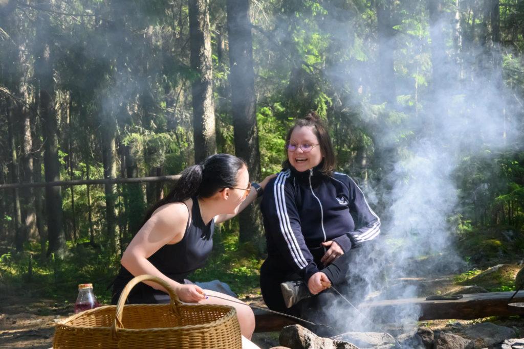 Retkeilijät nauravat nuotion äärellä