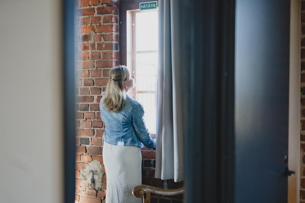 Nainen ja koira majoittumassa hotellihuoneeseen.