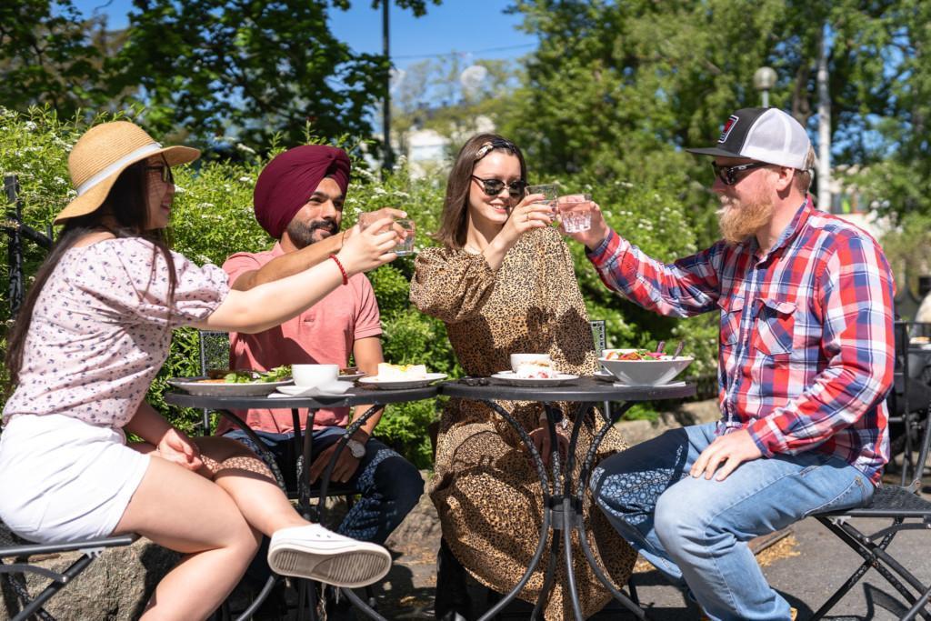 Ystävykset kohottavat maljat odottaessaan ruokaa