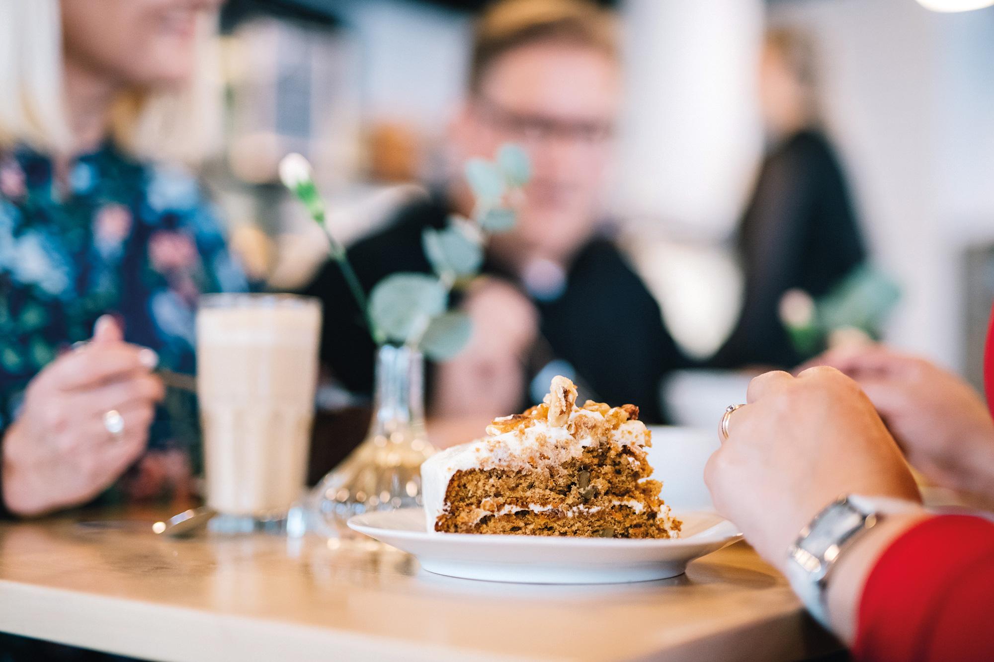 Ruokailijat nauttivat herkullisia leivoksia pöydän ääressä