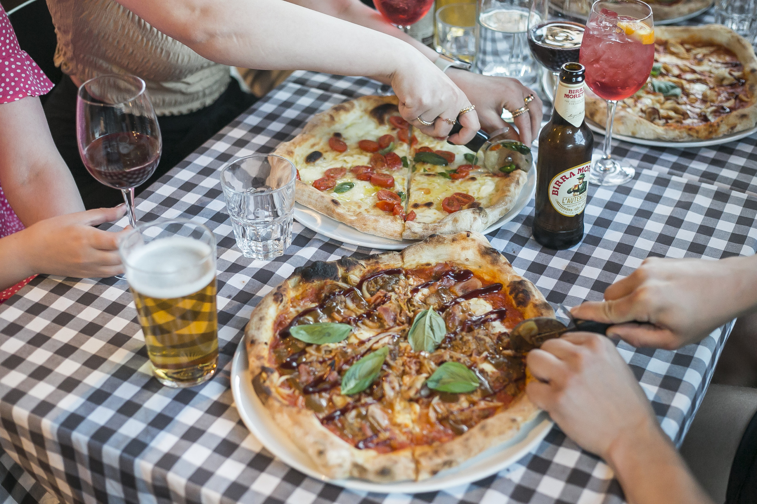 Johnny's Heist Pizzerian muhkeat Napolityyliset Pizzat ja juomat pöydällä