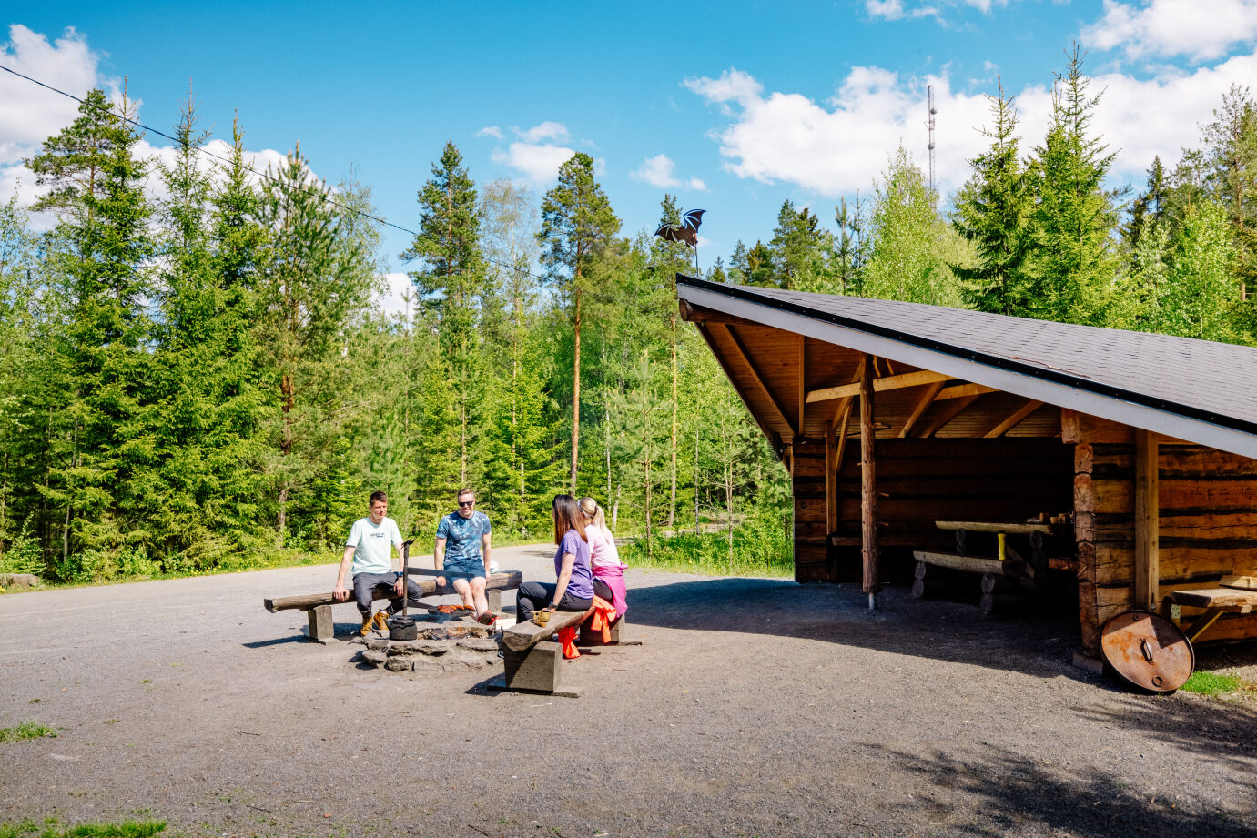 Ystävykset levähtävät laavulla luontoreitin varrella lähellä nuotiopaikkaa.