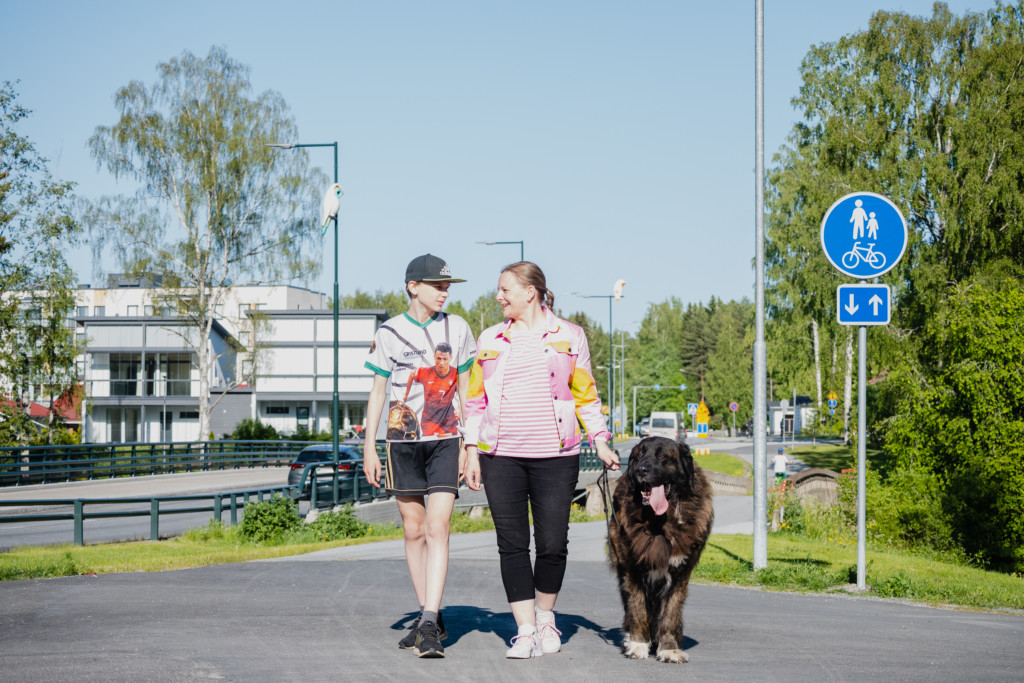 Äiti, poika ja koira kävelyllä