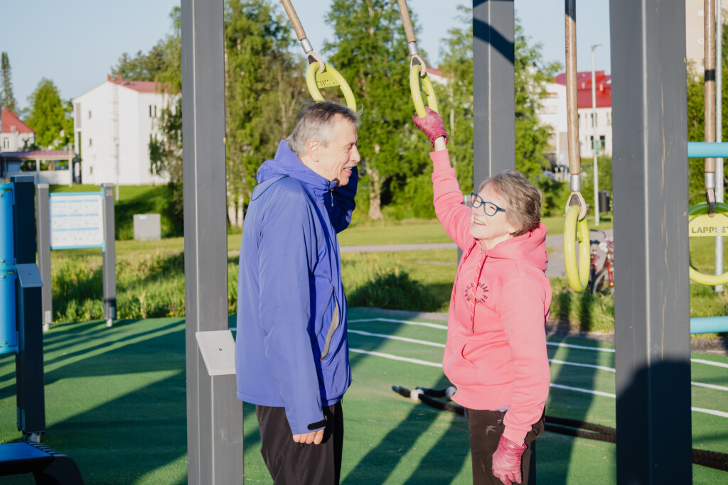 Mies ja nainen juttelevat toisilleen ulkokuntosalilla