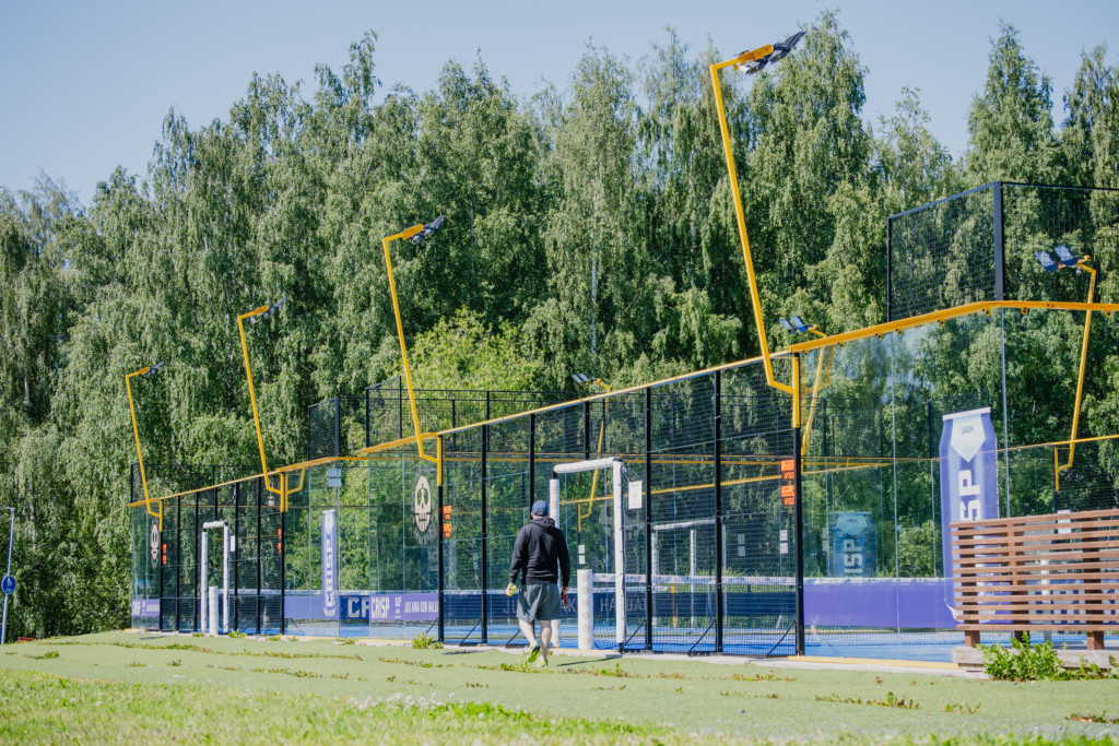 Mies kävelee kohti padelkenttää