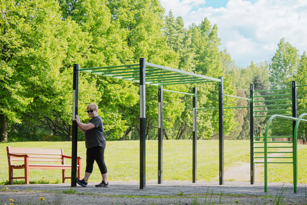 Nainnen venyttelee ulkoliikuntapaikalla