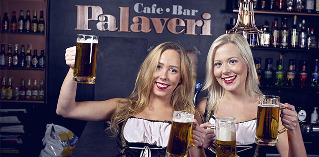 Palaverin baarityöntekijät nostavat maljaa oktoberfest tyylisissä asuissa.